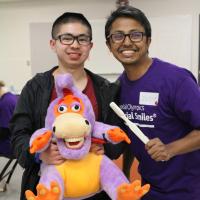 SOBC athlete Abraham Wong with dental care professional, holding a stuffed animal and tooth brush