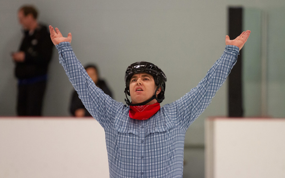 Special Olympics BC - Port Alberni athlete poses with his hands above his head at the end of his figure skating performance.
