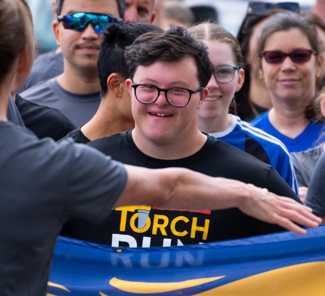 A close of Special Olympics BC athlete Reid Demelo as he runs with the Port Moody Police Department for the 2024 Law Enforcement Torch Run Torch Run event.