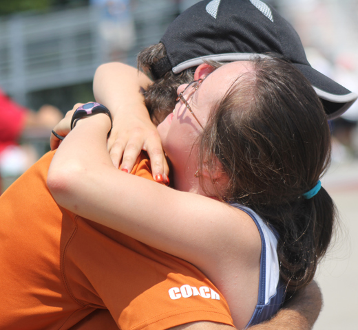 Athlete and coach hug