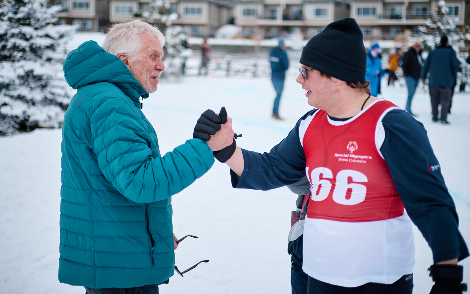 A snowshoeing athlete high fives his coach.