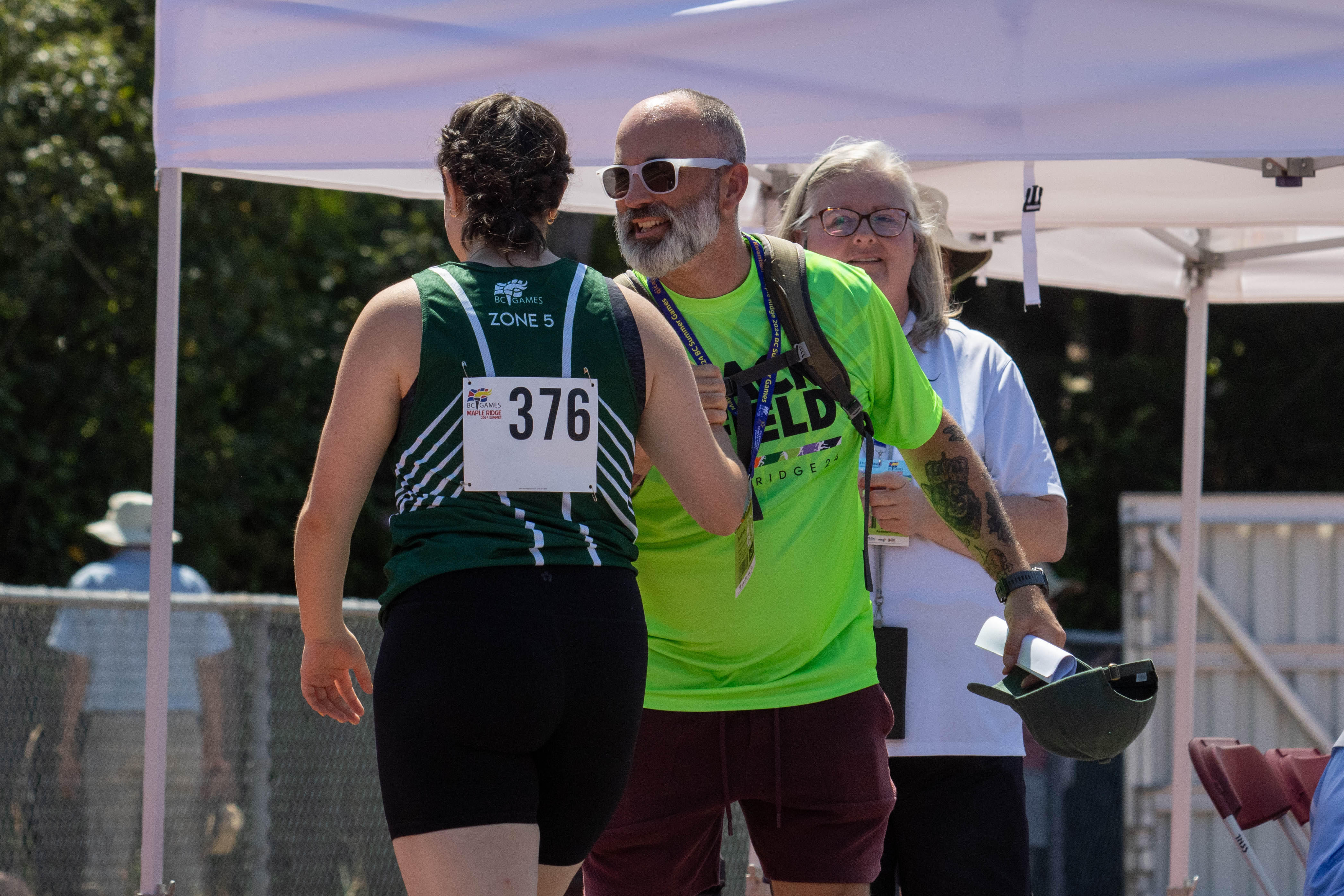 An athletics athlete high fives her coach at a competition. An athletics athlete high fives her coach at a competition.