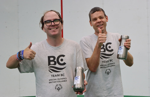 Two smiling athletes giving thumbs up.