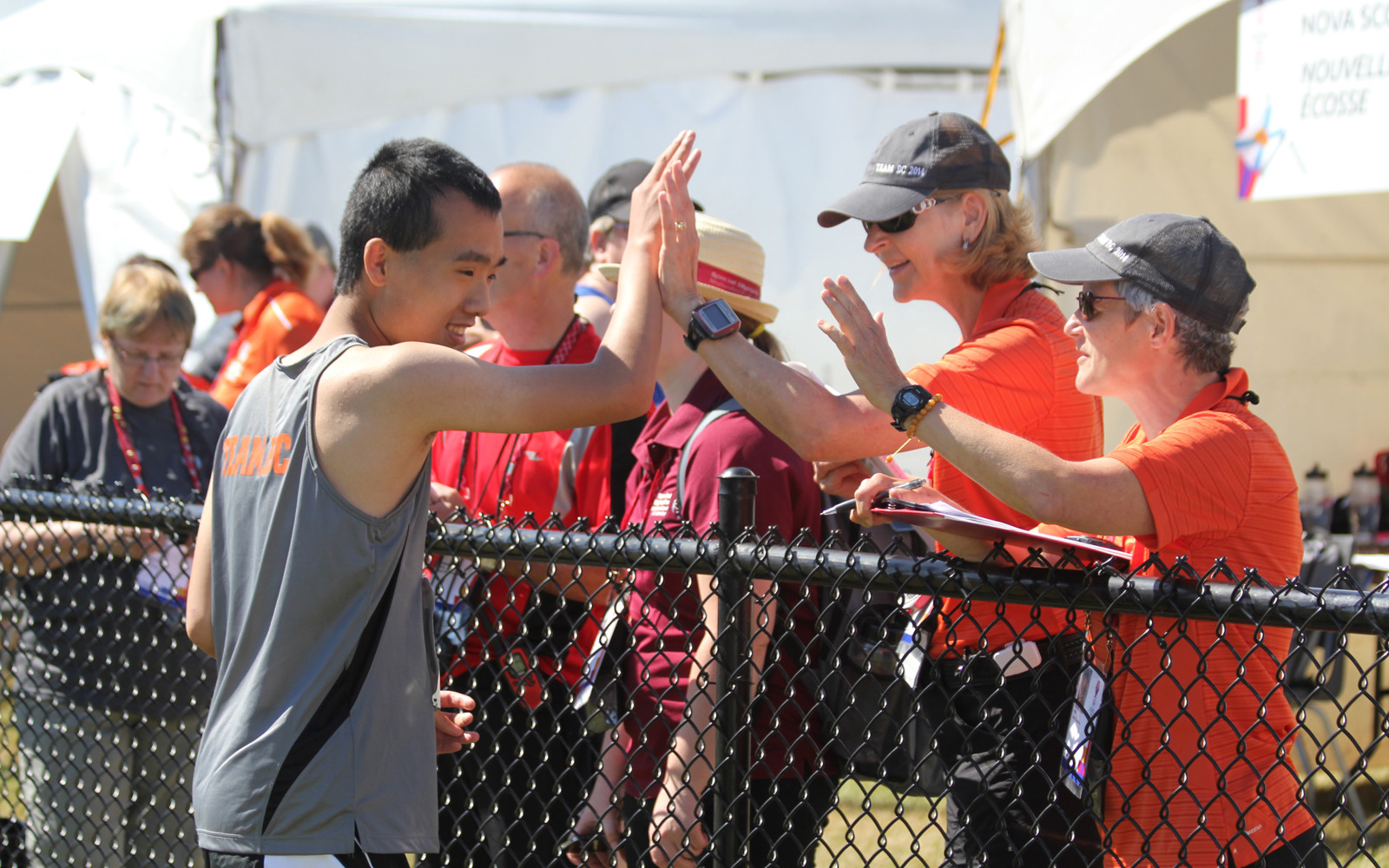 Special Olympics BC athlete gives a high five to their coaches.