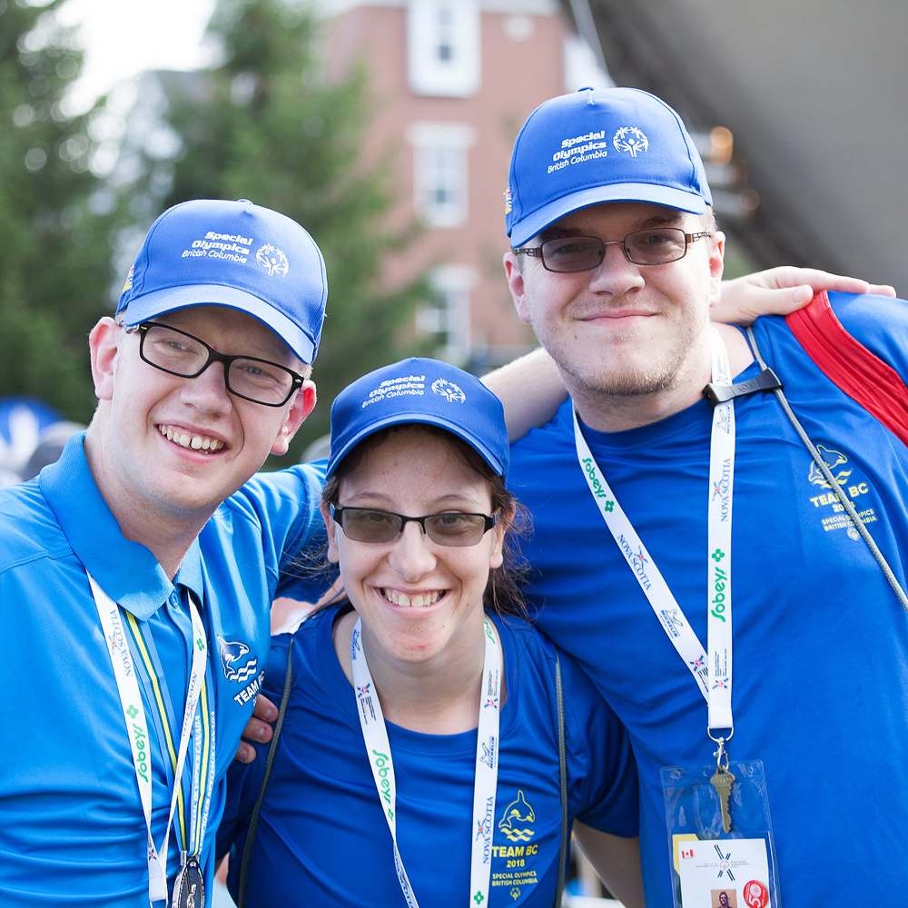 Three Special Olympics BC athletes pose for the camera wearing their Team BC apparel.